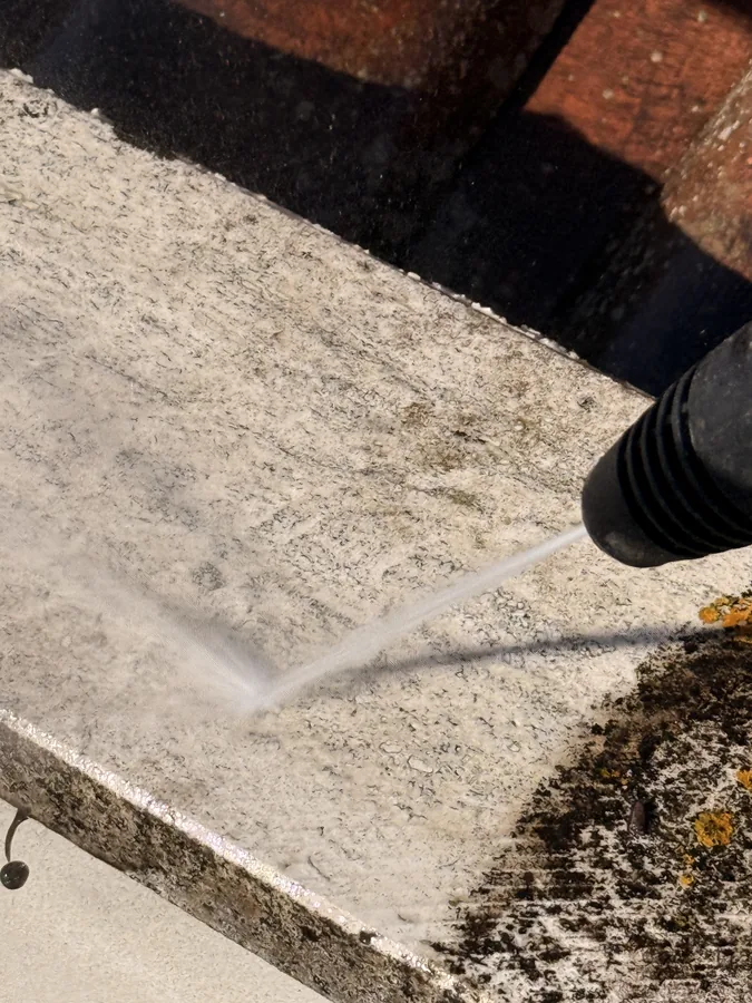 Getto d’acqua durante la pulizia della soglia sul bordo del tetto