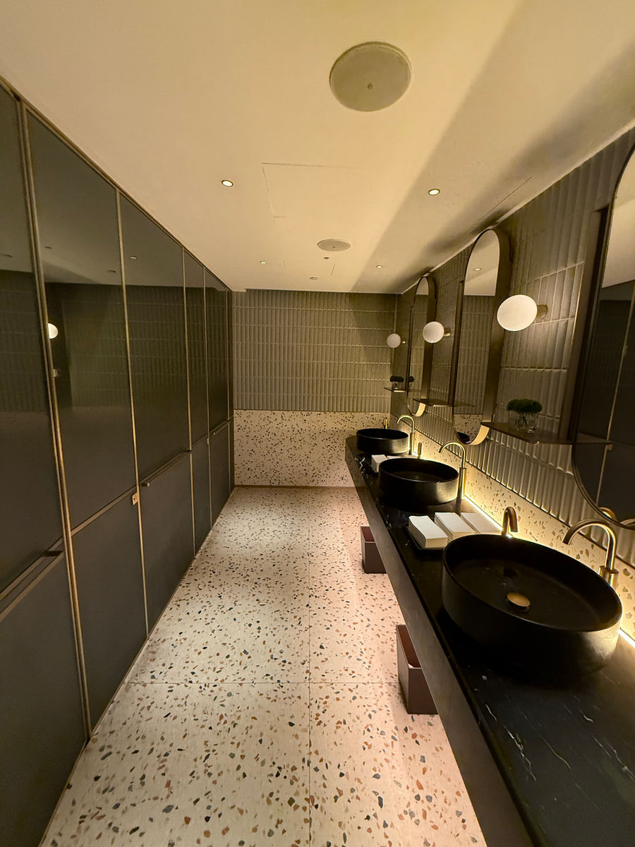 Bagno con lavabi neri e rivestimenti verdi