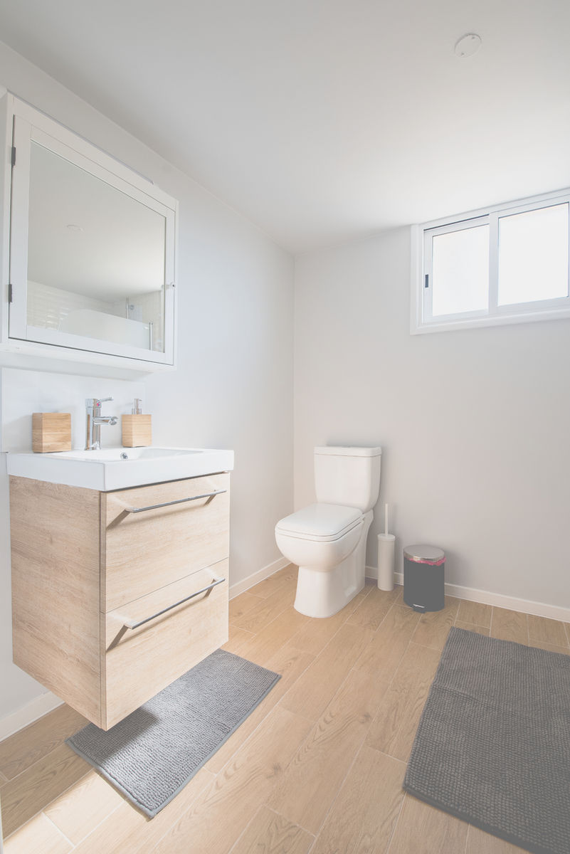 Bagno dai colori chiari con mobile lavabo in legno e pareti bianche